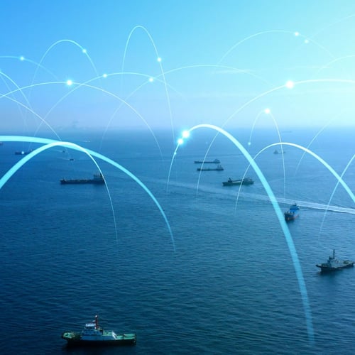 Aerial view of multiple ships on the ocean with overlaid arcs representing maritime communication networks, showcasing connectivity and the exchange of information between vessels